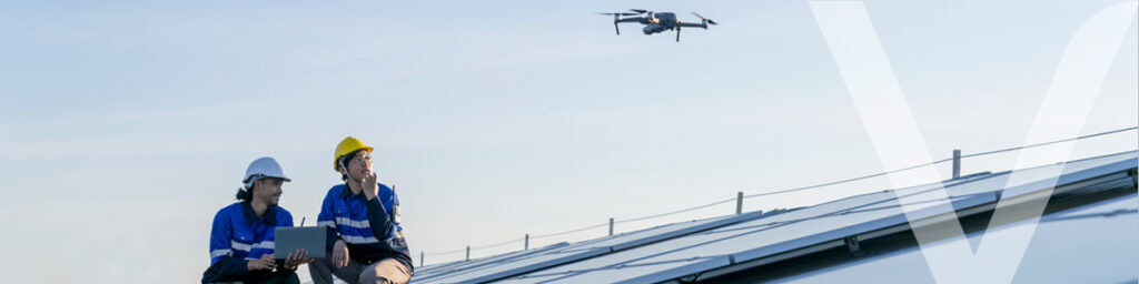 Two workers operating a drone and then analyzing the data obtained with artificial intelligence.