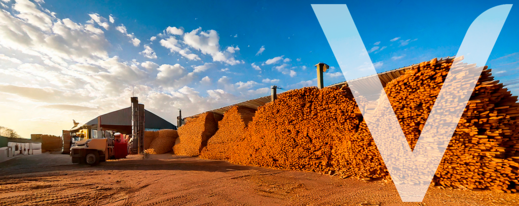 Piles of wood chips stacked at a sawmill, ready to be used as biomass for industrial processes or heating.